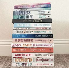 a stack of books sitting on top of a carpeted floor next to a wall