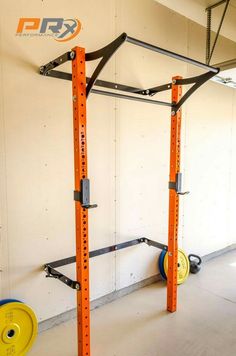 an empty gym room with squat racks and barbells