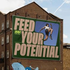 a large sign on the side of a building that says feed your potential with an image of a man jumping