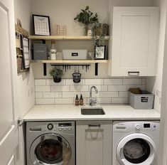 a washer and dryer in a small room with open shelves on the wall