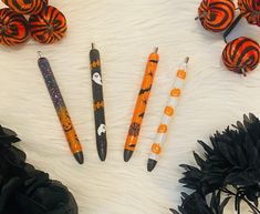 four halloween themed pens sitting on top of a white fur covered floor next to pumpkins