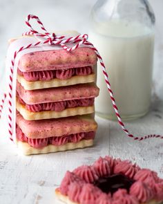 some cookies are stacked on top of each other next to a glass of milk