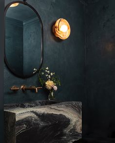 a bathroom with a marble sink and black walls