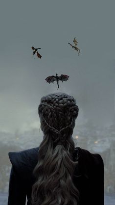 the back of a woman's head with dragon wings flying above her and two birds in the sky