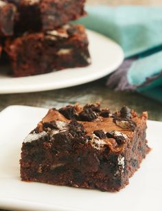 two white plates topped with brownies on top of a table