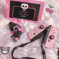 two pink video game controllers sitting next to each other on a white fur covered surface