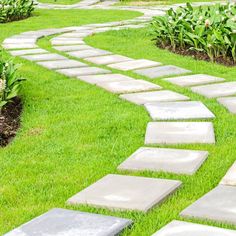 a stone path in the middle of a grassy area