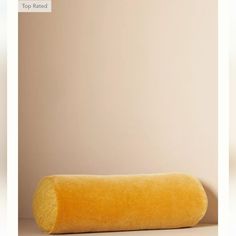 a roll of yellow material sitting on top of a white floor next to a wall