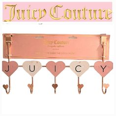 the juicy couture key holder is pink and has hearts hanging from it's hooks