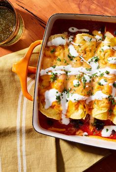 an enchilada dish with sour cream on top