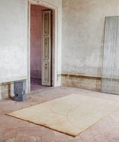 an empty room with two doors and a rug on the floor