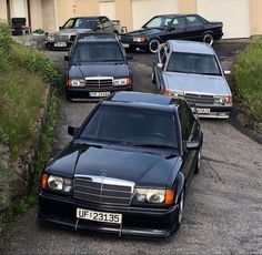 three mercedess are parked in front of two garage doors, one is black and the other is silver