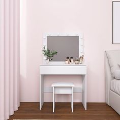 a white dressing table with a mirror and stool in a pink room next to a bed