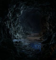 a dark cave filled with lots of water next to a light at the end of it