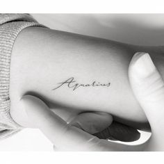 a woman's arm with the word analis tattooed on her left side ribcage