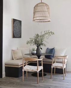 a living room filled with furniture and a lamp hanging from the ceiling over a table