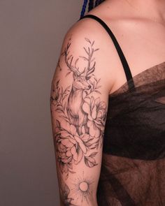 a woman with a deer and flowers tattoo on her arm