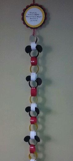 a clock made to look like mickey mouses head hanging from the side of a wall