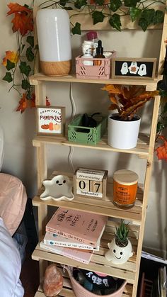 a shelf filled with books and plants next to a bed