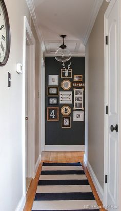 the hallway is decorated with photos and pictures on the wall, along with a clock