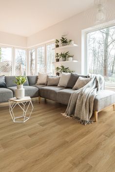 a living room filled with furniture and lots of windows next to a large wooden floor