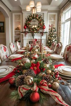 a dining room table decorated for christmas with red and gold decorations