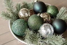 a bowl filled with green and silver ornaments