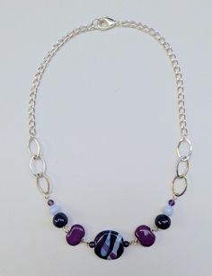 Plum, white and deep purple Kazuri fair trade ceramic pendant is flanked by glass and Kazuri beads (in plum and white), with a mix of silver loops.  It's 18" and on a silver-tone aluminum chain.  (Nickel-free and lead-free) Please visit my shop to discover other styles and colors: https://www.etsy.com/ca/shop/LesHetherDesigns Kazuri Bead Jewelry, Kazuri Beads, Ceramic Pendant, Bead Jewelry, Fall 2024, Link Necklace, Deep Purple, Fair Trade, Pendant Necklaces