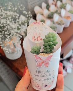 a person holding up a cup with succulents in it and the words hello