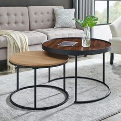 two tables sitting on top of a rug next to a couch