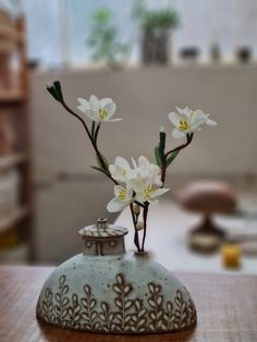 a vase with flowers in it sitting on a table