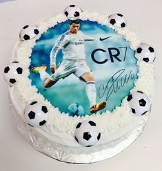 a birthday cake with a soccer player on the frosting and balls in front of it