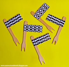 four wooden clothes pins with black and white designs on them, sitting on a yellow background