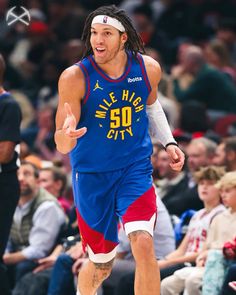 a basketball player is running on the court with his hand out to someone in front of him