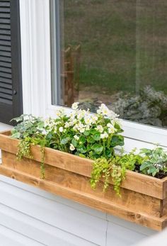 a wooden window box with flowers in it