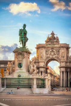 the statue is in front of an ornate arch with statues on it's sides