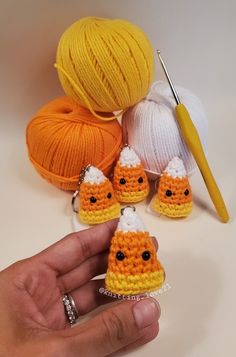 there is a crochet kit with three little pumpkins on it and two balls of yarn in the background