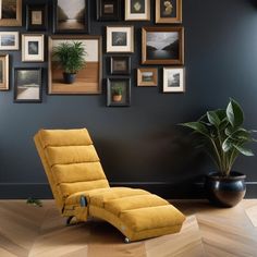 a yellow reclining chair sitting in front of a wall with framed pictures on it