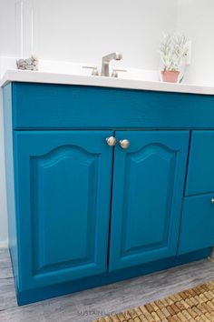 a bathroom with blue cabinets and a white sink