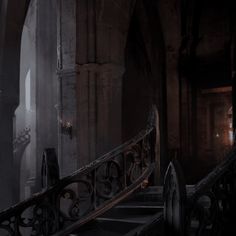 a dark hallway with an iron hand rail and railings in the middle of it