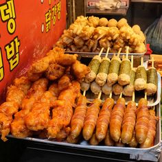 several different types of food on sticks in a display case at a street vendor's stall