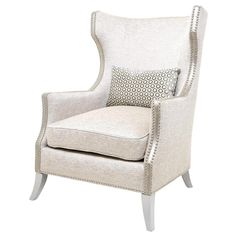 an upholstered chair with white fabric and beading on the armrests