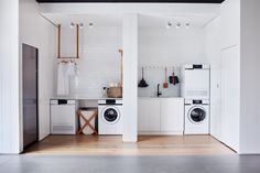 a white kitchen with washer and dryer next to each other in the room