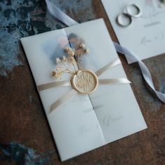 a wedding card with a ring on it and a ribbon tied around the back of it