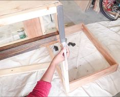 a person is working on some kind of wooden structure with woodworking tools in front of them