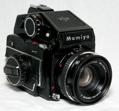 an old fashioned camera sitting on top of a white surface with the words mamiya written on it