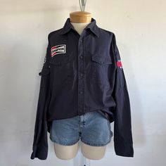 "Embrace a touch of Americana with this vintage Dickies workshirt. Adorned with Route 66 and Champion patches, it's a nod to classic American culture. Made from 100% cotton, this size Large shirt combines durability and style for a timeless addition to your wardrobe. era: 1980s label size: L [please check measurements] fits like: large measurements: bust: 48\" waist: 44\" length: 30\" material: 100% cotton brand/maker: Dickie's condition: excellent vintage condition [ please see photos ] Thanks Vintage Streetwear Shirt With Pockets, Cotton Camp Shirt With Pockets And Long Sleeves, Long Sleeve Cotton Camp Shirt With Pockets, Cotton Long Sleeve Camp Shirt With Pockets, Cotton Long Sleeve Shirt With Patches, Vintage Crew Neck Top With Pockets, Casual Button-up Tops With Patches, Retro Cotton Tops With Pockets, Cotton Long Sleeve Tops With Patches