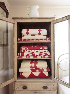 towels are stacked on top of each other in an old cabinet