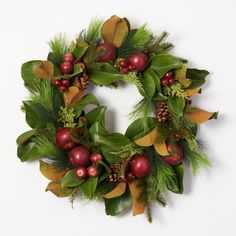 a christmas wreath with green leaves and red berries