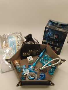 an open box containing various items including dice, pens and other things to play with